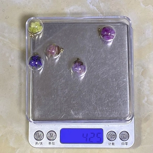Macro detail of dried flower glass globes on a scale showing 4.25g weight specification