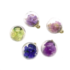 Clear glass globe pendants with colorful dried flowers and golden metal loops