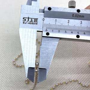 Nahaufnahme der 3-4mm weißen ABS-Perlenkette mit goldenem Draht und Messschieber