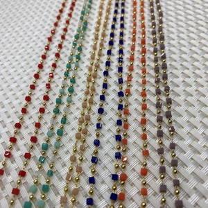 Detail of multi-colored cube stone beads with gold spacer beads on 10m roll for DIY jewelry