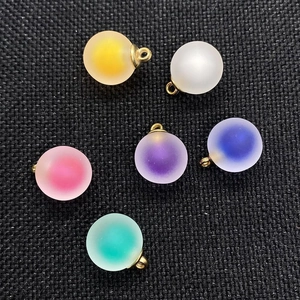 Detail of 16mm matte acrylic round ball pendants in multiple gradient colors with gold loops