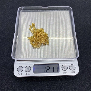 Close-up of 12.11g golden beaded twist chain on a precision scale for DIY jewelry making