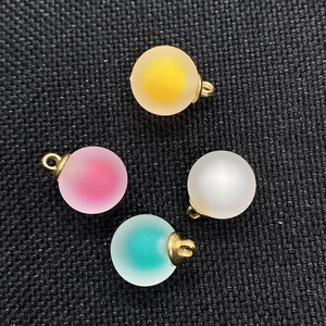 Detailed macro view of 16mm matte acrylic round ball pendants in four pastel colors