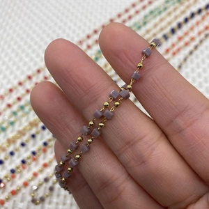 Macro shot of 10m roll purple stone cube beads and gold metal ball DIY jewelry chain