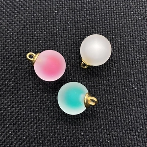 Detail of 16mm matte acrylic ball pendants in pink, white, and teal with gold loops