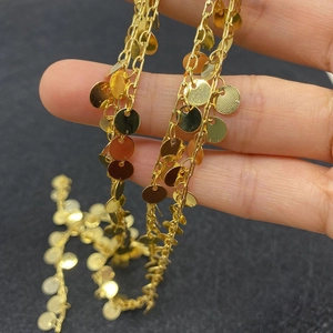 Detailed macro view of golden twisted chain with polished round sequin dangles