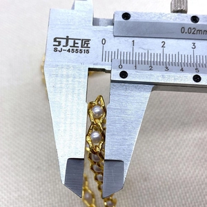 Vista dettagliata della larghezza di 8,8 mm della catena di perle dorate con calibro