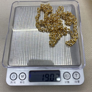 Dettaglio della catena dorata con perle bianche su bilancia che segna 19,02 g