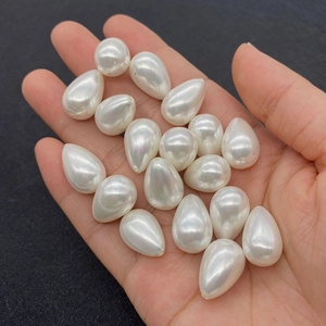 Macro detail of white teardrop imitation pearls with glossy finish for DIY jewelry