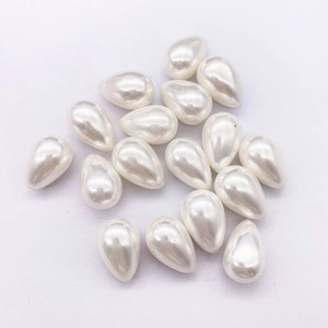 Macro detail of teardrop-shaped white faux pearls with polished glossy finish for DIY jewelry