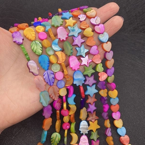 Macro shot of colorful shell beads in various shapes like heart star and moon for DIY jewelry