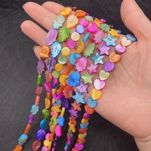 Macro shot of colorful shell beads in star, heart, and crescent shapes for DIY jewelry