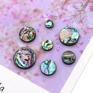 Macro detail of natural round abalone shell beads showing iridescent colorful luster textures