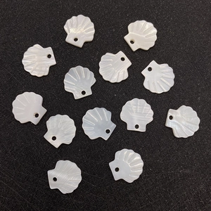 Macro shot of 12mm fan-shaped natural shell pendants with pre-drilled holes for DIY