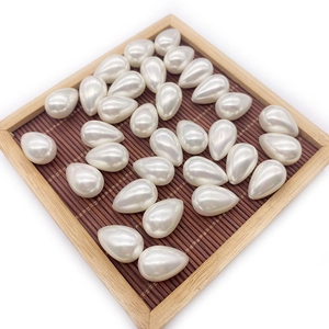 Lustrous white teardrop imitation pearls for DIY jewelry making in a wooden tray