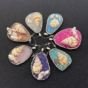 Macro detail of teardrop shell pendants with rhinestone edges in various colors