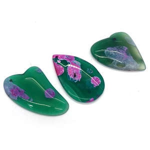 Polished agate stone pendants in teardrop and heart shapes with magenta natural textures