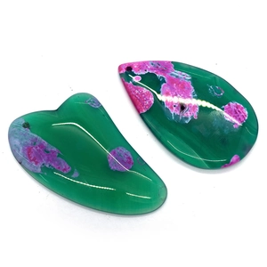 Macro shot of heart and teardrop shaped natural green agate pendants with pink floral patterns