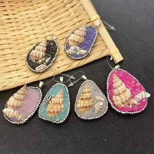 Detail of drop-shaped shell pendants with colorful crushed stones and sparkling rhinestones