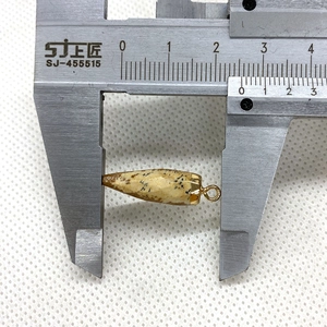 Lengtemeting van de kogelvormige natuursteen hanger met gouden metalen kap op een schuifmaat