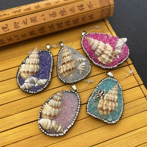 Macro detail of five teardrop shell pendants with colorful crystals and rhinestones