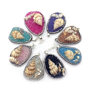 Detailed view of eight teardrop ocean shell pendants with rhinestone edges