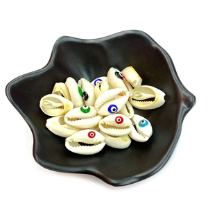 Natural conch evil eye shell beads in a black decorative tray for DIY jewelry making