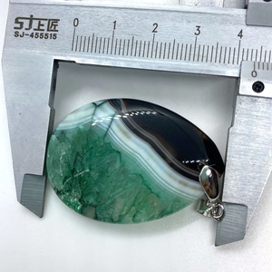 Detail view of large teardrop agate pendant measured with calipers for precise 44mm size