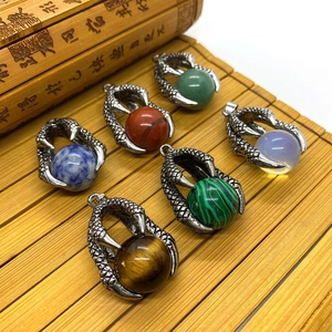 Detailed view of silver dragon claw pendants holding colorful round natural stone beads