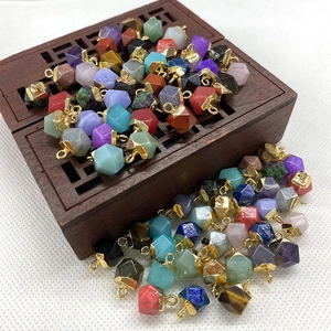 Close-up of hexagonal natural stone pendants with gold metal caps on a wooden box