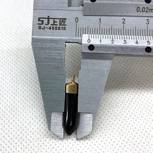 Measuring 8mm width of bullet shape black gemstone pendant with gold metal cap with caliper