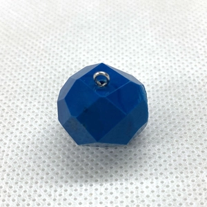 Macro detail of faceted dark blue crystal ball pendant with metal ring connector
