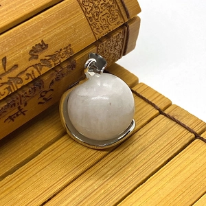 Macro detail of natural rose quartz round gemstone pendant with silver metal frame