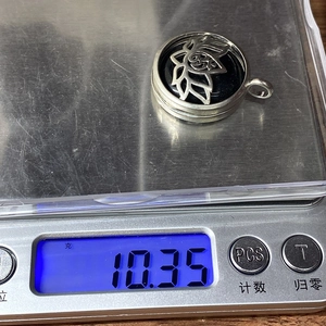 Zilveren Om lotus hanger op een elektronische weegschaal met gewicht van 10,35g