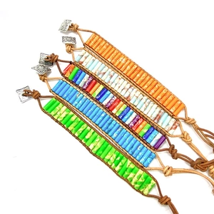 Detail showing five boho tubular stone bead bracelets with leather cords and silver buckles