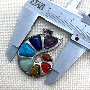 Detail view of 7 chakra snail pendant measured with a digital caliper showing 2.8cm width