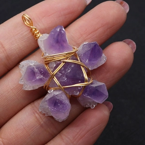Handcrafted purple amethyst cluster star pendant with gold wire wrap on black background