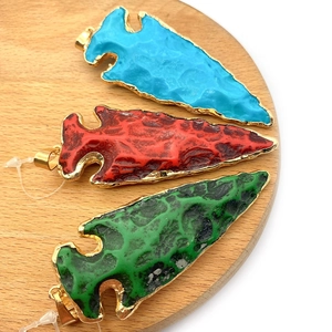 Drie pijlvormige hars hangers in blauw, rood en groen met stijlvolle gouden randen