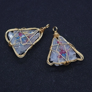 Macro detail of triangle wire-wrapped white crystal pendants with gold metal wire and colorful stones