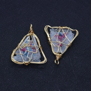 Macro detail of handmade wire-wrapped crystal pendants with colorful stones and gold wire