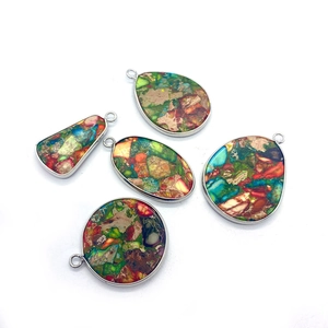 Cinq pendentifs en pierre naturelle de formes variées avec bordures métalliques argentées