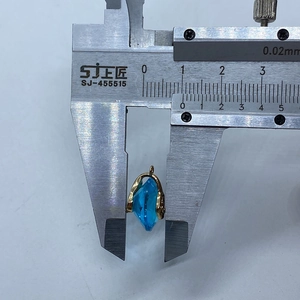 Macro view of a 7.5mm blue teardrop crystal pendant with gold claw setting and bail