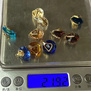 Detailed weighing of various faceted heart-shaped stone pendants with gold metal clasps