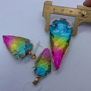 Vue détaillée de pendentifs en cristal irisé en forme de flèche avec bordure dorée et pied à coulisse