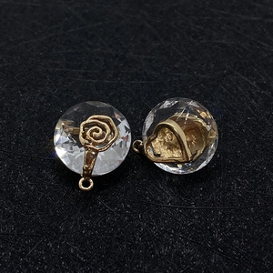 Natural faceted crystal round flower and heart gold pendants on black textured background