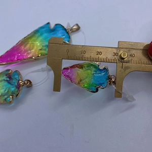 Mesure détaillée de la largeur du pendentif en pierre colorée avec un pied à coulisse en laiton
