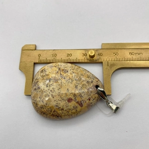Mesure précise d'un pendentif goutte en pierre naturelle marron avec un pied à coulisse