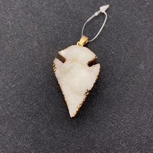 Primer plano del colgante de cristal druzy blanco en forma de flecha con bordes dorados