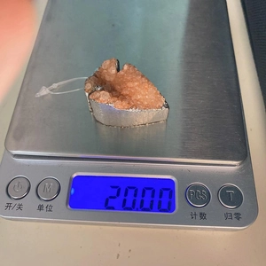 Medición del peso de un colgante de cristal natural en forma de corazón en báscula de 20g