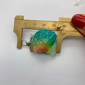 Meten van de kleurrijke kristallen hanger omwikkeld met zilverdraad met een schuifmaat